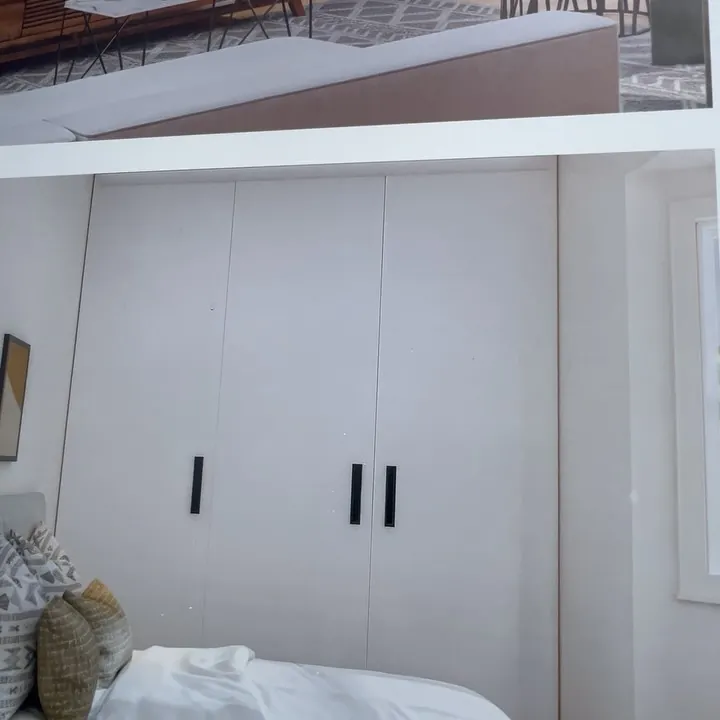 White fitted wardrobes with black handles in a bedroom in Lewisham