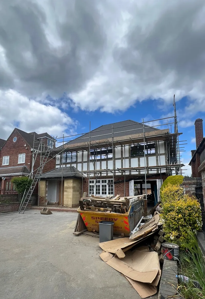 Front of a detached house in Ickenham with a skip on the driveway at the start of refurbishment work