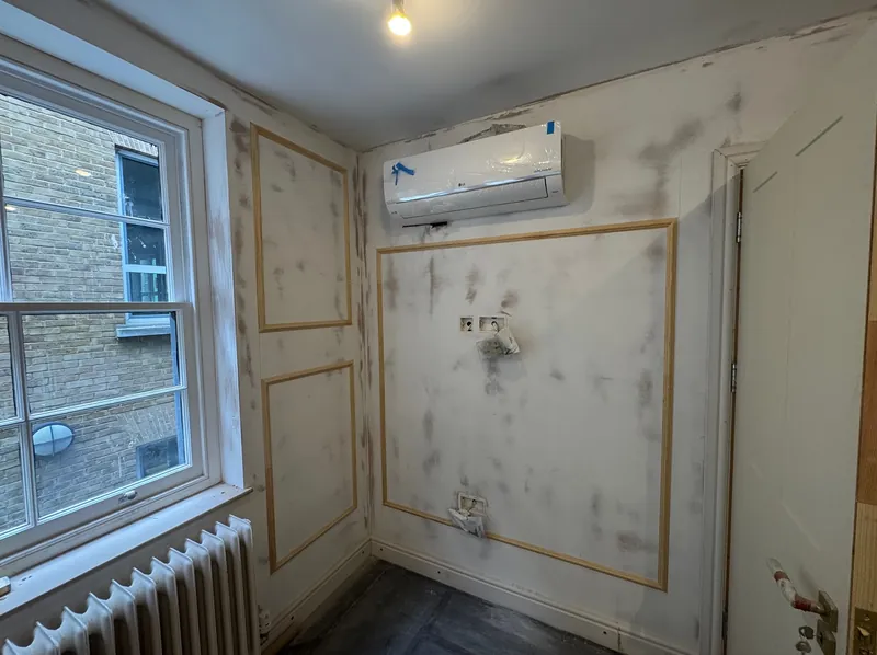 Decorative panel mouldings fitted to a wall in a Mayfair flat, ready for painting